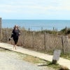 A teacher walks barefoot by the beach