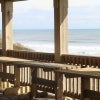 Wooden tables laid out on a porch next to the sea